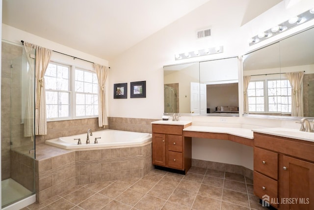 bathroom with lofted ceiling, a stall shower, plenty of natural light, and a garden tub