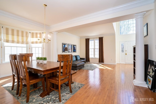 dining area featuring ornate columns and light wood-style floors