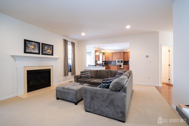 living area with recessed lighting, light carpet, a fireplace, and baseboards