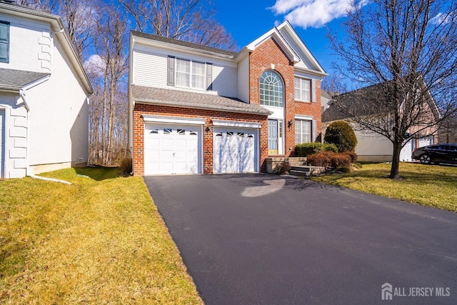 view of front of house with driveway, a garage, a front yard, and brick siding