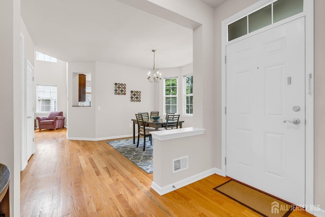 1206 Fir Ct, Franklin Twsp, NJ 08873 - foyer with light wood-style flooring and a chandelier