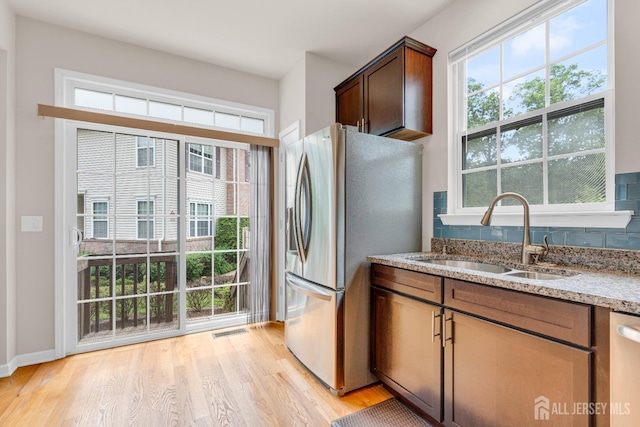 1206 Fir Ct, Franklin Twsp, NJ 08873 - kitchen featuring appliances with stainless steel finishes, light wood-type flooring, light stone countertops, and tasteful backsplash
