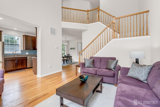 1206 Fir Ct, Franklin Twsp, NJ 08873 - living area featuring a towering ceiling, light wood finished floors, stairway, a chandelier, and recessed lighting