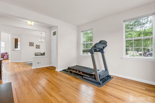 1206 Fir Ct, Franklin Twsp, NJ 08873 - workout room featuring light wood finished floors and a chandelier