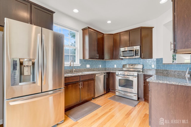 1206 Fir Ct, Franklin Twsp, NJ 08873 - kitchen featuring stainless steel appliances, light stone counters, light wood finished floors, backsplash, and recessed lighting