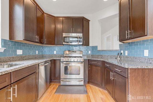 1206 Fir Ct, Franklin Twsp, NJ 08873 - kitchen featuring stainless steel appliances, light wood-style flooring, light stone counters, and decorative backsplash