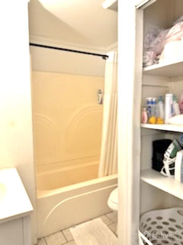 full bathroom featuring toilet, vanity, tile patterned floors, and shower / tub combo with curtain