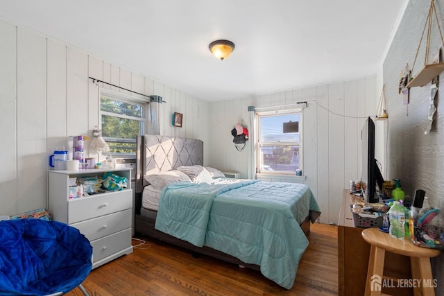 bedroom featuring multiple windows and wood finished floors