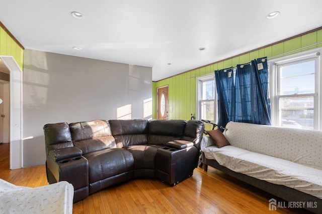 living area with recessed lighting, light wood-style floors, and wooden walls