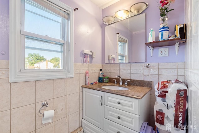 bathroom featuring a wainscoted wall, tile walls, and vanity