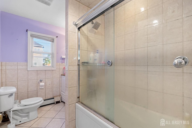 full bath with a wainscoted wall, bath / shower combo with glass door, tile patterned flooring, tile walls, and toilet