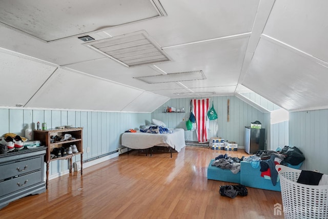 bedroom featuring vaulted ceiling, a baseboard heating unit, and wood finished floors