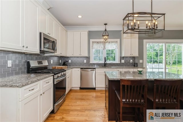 19 Maplehurst Ln, Piscataway, NJ 08854 - kitchen with stainless steel appliances, a chandelier, white cabinets, light wood finished floors, and crown molding