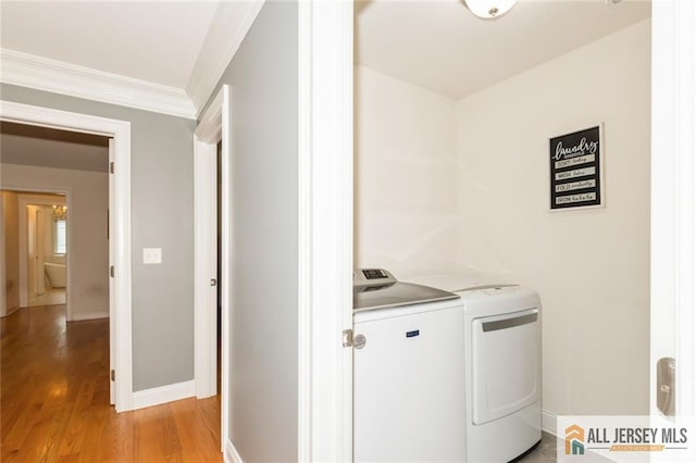 19 Maplehurst Ln, Piscataway, NJ 08854 - laundry room with washing machine and dryer, ornamental molding, and light wood-type flooring