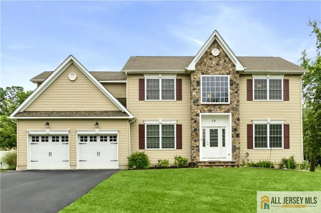 19 Maplehurst Ln, Piscataway, NJ 08854 - view of front of house featuring driveway, a front yard, an attached garage, and stone siding