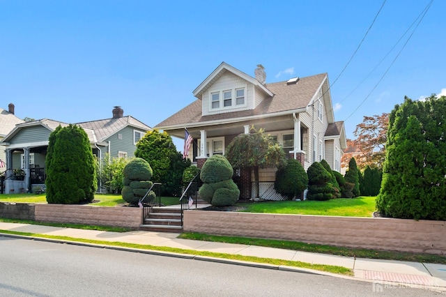 view of front of home featuring a front yard and covered porch