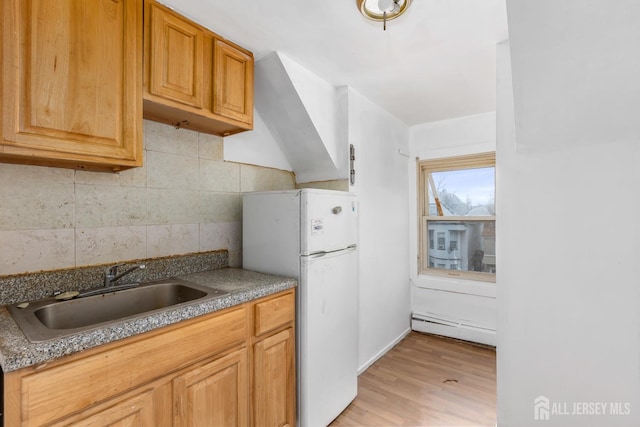 107 N 16th St N, East Orange, NJ 07017 - kitchen with a sink, a baseboard heating unit, freestanding refrigerator, backsplash, and light wood-style flooring