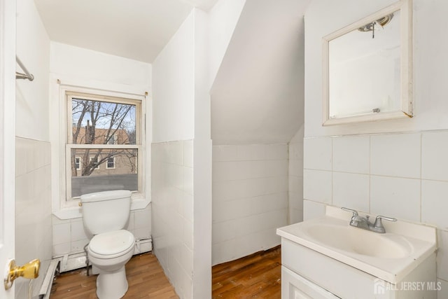 107 N 16th St N, East Orange, NJ 07017 - half bathroom featuring tile walls, toilet, wood finished floors, vanity, and a baseboard heating unit