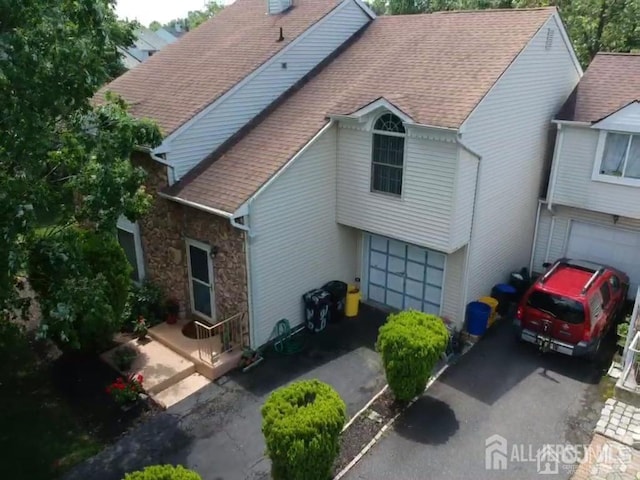 29 Jeffrey Cir S, Brunswick, NJ 08810 - back of house with asphalt driveway, a garage, a shingled roof, and a chimney