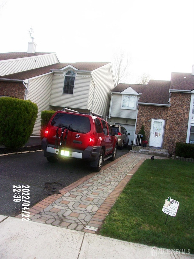 29 Jeffrey Cir S, Brunswick, NJ 08810 - view of front of house with stone siding, roof with shingles, and a front lawn