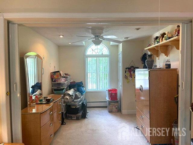 29 Jeffrey Cir S, Brunswick, NJ 08810 - bedroom featuring a baseboard radiator, light colored carpet, and ceiling fan