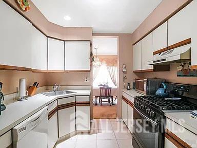29 Jeffrey Cir S, Brunswick, NJ 08810 - kitchen with black gas stove, under cabinet range hood, white dishwasher, white cabinets, and light countertops