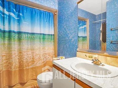 29 Jeffrey Cir S, Brunswick, NJ 08810 - full bath with vanity, wallpapered walls, and shower / tub combo with curtain