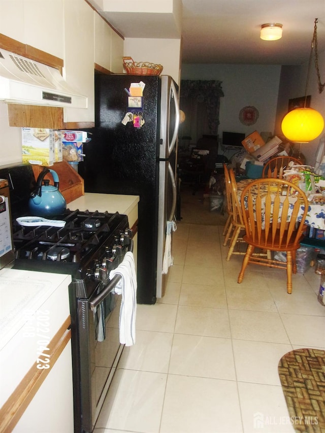 29 Jeffrey Cir S, Brunswick, NJ 08810 - kitchen with black gas range oven, premium range hood, light tile patterned floors, and freestanding refrigerator