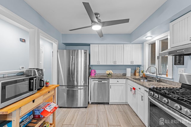 kitchen featuring stainless steel appliances, white cabinetry, and a sink