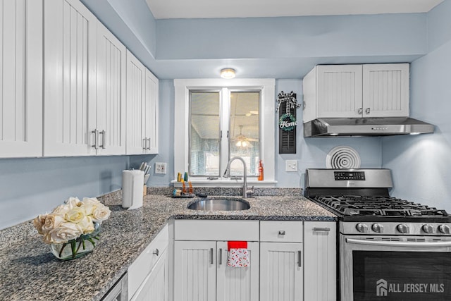 kitchen featuring a sink, stainless steel gas range, under cabinet range hood, and white cabinetry