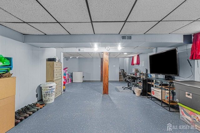 finished basement featuring visible vents and a drop ceiling