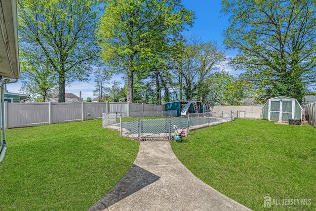 view of yard featuring an outdoor structure, a fenced backyard, and a shed