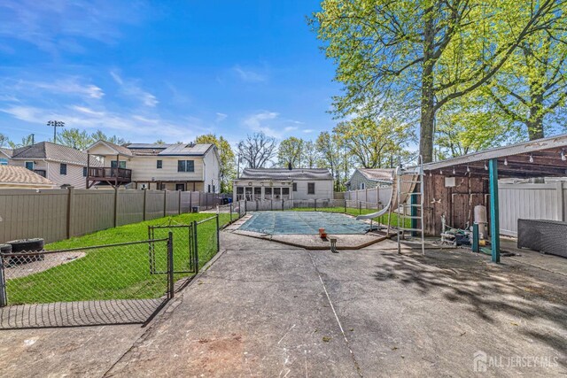 exterior space featuring a patio, a fenced backyard, a pool, a lawn, and a residential view