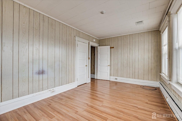 151 N Broadway N, South Amboy, NJ 08879 - spare room featuring a baseboard heating unit, healthy amount of natural light, wood finished floors, wood walls, and crown molding
