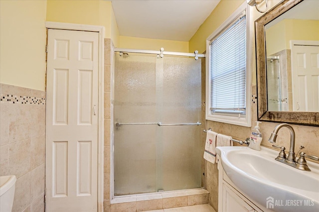 151 N Broadway N, South Amboy, NJ 08879 - bathroom with tile walls, a shower stall, vanity, toilet, and wainscoting