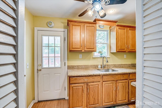 151 N Broadway N, South Amboy, NJ 08879 - kitchen with a sink, ceiling fan, light wood-type flooring, light stone countertops, and brown cabinets