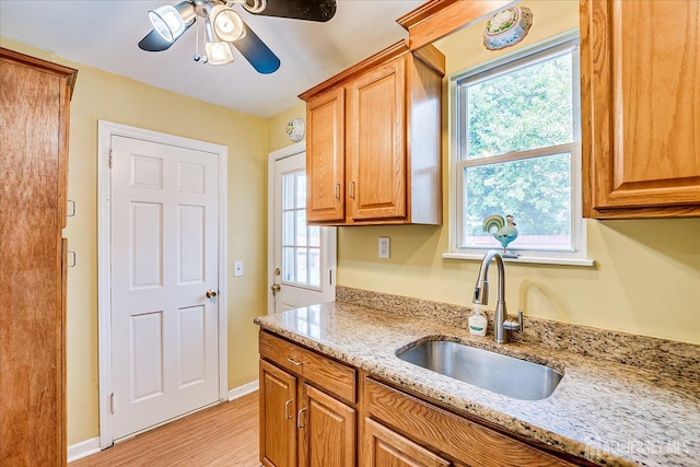 151 N Broadway N, South Amboy, NJ 08879 - kitchen with a sink, a ceiling fan, light wood-style floors, light stone countertops, and brown cabinets
