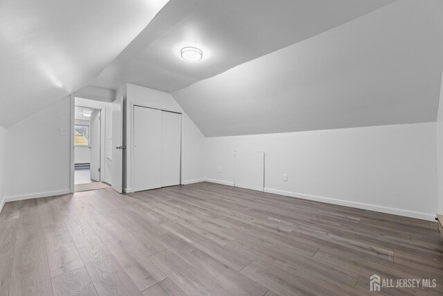 bonus room featuring lofted ceiling and light wood-type flooring