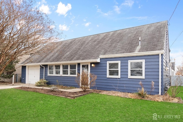 view of front of property featuring an attached garage, concrete driveway, a front lawn, and a shingled roof