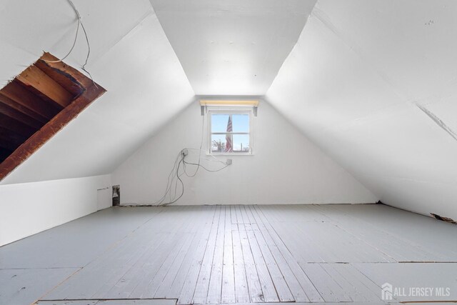 bonus room with hardwood / wood-style flooring and vaulted ceiling