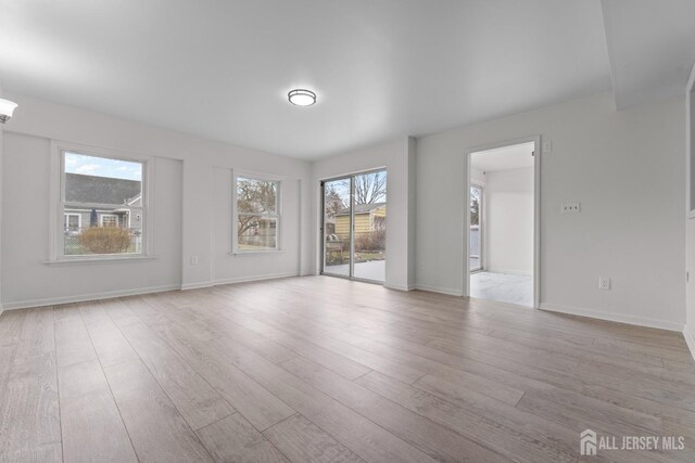 spare room featuring light wood-type flooring and a wealth of natural light