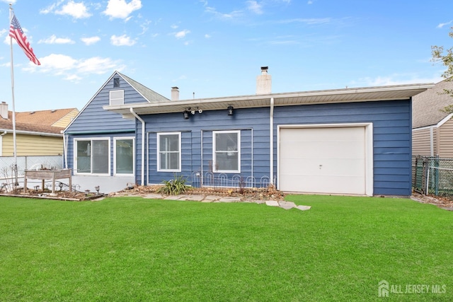 back of property with a yard and a garage