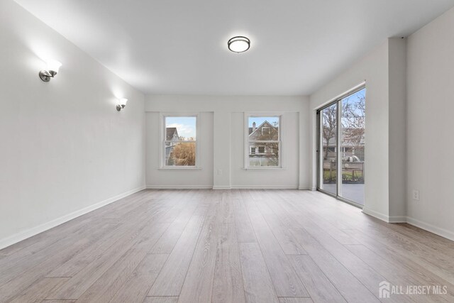 unfurnished room with light wood-type flooring and a wealth of natural light