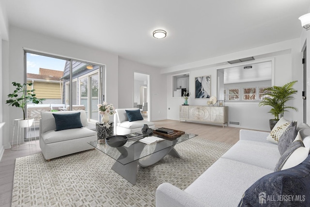 living room with visible vents and wood finished floors