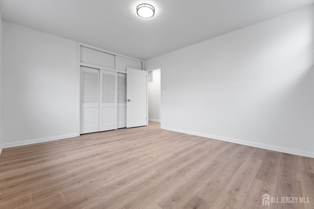 unfurnished bedroom featuring a closet and light hardwood / wood-style floors