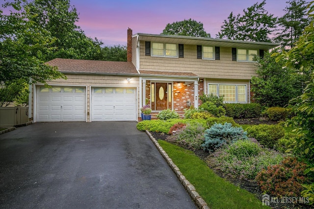 10 Dellview Dr, Edison, NJ 08820 - colonial house featuring a chimney, an attached garage, driveway, and brick siding