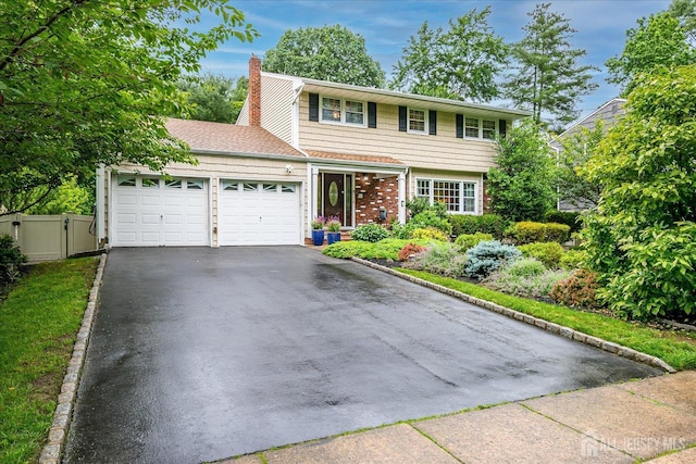 10 Dellview Dr, Edison, NJ 08820 - colonial house with a garage, a chimney, asphalt driveway, brick siding, and a gate