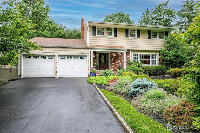 10 Dellview Dr, Edison, NJ 08820 - colonial house with an attached garage, a chimney, asphalt driveway, and brick siding