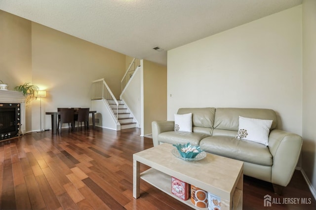 349 Lunar Rd, Piscataway, NJ 08854 - living room with stairway, wood finished floors, lofted ceiling, a fireplace, and a textured ceiling