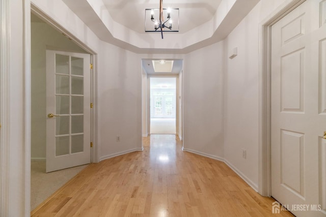 1109 Cedar Village Blvd, East Brunswick, NJ 08816 - hall with light wood-style floors, baseboards, and a chandelier